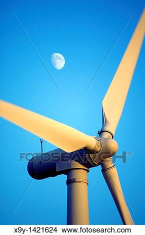 Wind turbine rotors with blue sky and moon generating electricity on wind farm at Bryn Titli near Rhayader, central Wales, UK View Large Photo Image Picture - Wind turbine rotors with blue sky and moon generating electricity on wind farm at Bryn Titli near Rhayader, central Wales, UK. Fotosearch