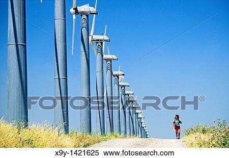 Wind turbines, part of the massive wind farm complex at Altamont near Livermore, California, USA Woman walking on track View Large Photo Image Stock Photography - Wind turbines, part of the massive wind farm complex at Altamont near Livermore, California, USA Woman walking on track. Fotosearch