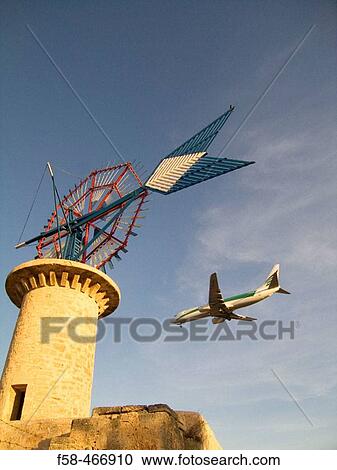 Windmill and airplane landing. Son Sant Joan airport. Palma de Mallorca. Balearic Islands. Spain. View Large Photo Image Stock Image - Windmill and airplane landing. Son Sant Joan airport. Palma de Mallorca. Balearic Islands. Spain.. Fotosearch