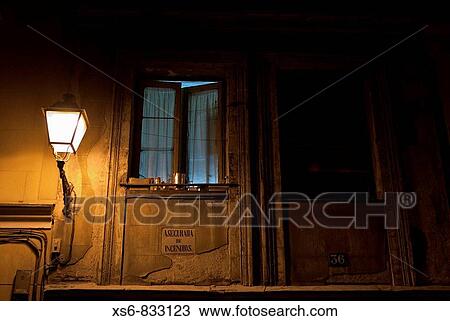 Stock Image - Window of a house at night in downtown Madrid. Fotosearch