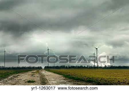 Windpark in North Rhine-Westphalia, Germany with a lignite-fired power plant in the background. Long exposure with motion blurred blades. Dramatic winter sky. View Large Photo Image Stock Photo - Windpark in North Rhine-Westphalia, Germany with a lignite-fired power plant in the background. Long exposure with motion blurred blades. Dramatic winter sky.. Fotosearch