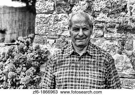 Stock Image - Wine field worker at vineyard in romantic Tuscany near Siena Italy. Fotosearch