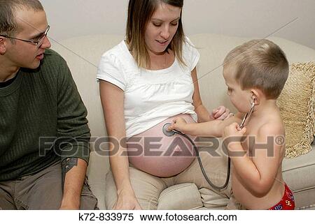 With a stethoscope this youngster is trying to hear the heartbeat of his new brother still inside the mommy View Large Photo Image Stock Photography - With a stethoscope this youngster is trying to hear the heartbeat of his new brother still inside the mommy. Fotosearch