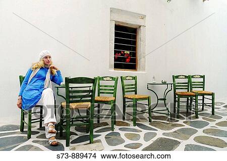 Womaan sitting in a restaurant, Mykonos, Cyclades Islands, Greece View Large Photo Image Picture - Womaan sitting in a restaurant, Mykonos, Cyclades Islands, Greece. Fotosearch