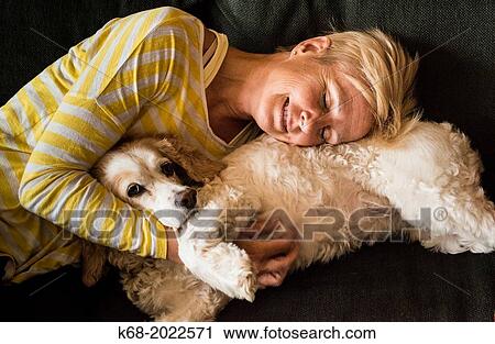 woman, 54, hugs a spaniel on a sofa View Large Photo Image Stock Image - woman, 54, hugs a spaniel on a sofa. Fotosearch