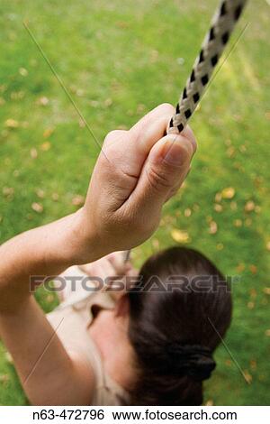 Stock Photograph - Woman abseiling down a rope,. Fotosearch