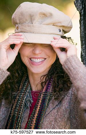 Woman adjusting her hat View Large Photo Image Stock Photo - Woman adjusting her hat. Fotosearch