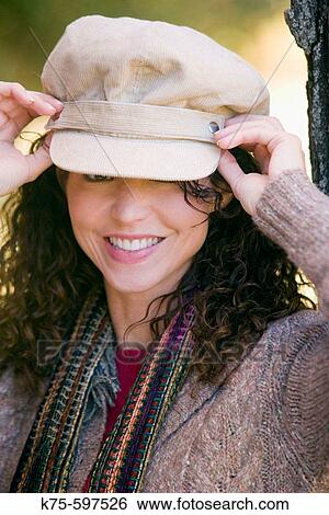 Woman adjusting her hat View Large Photo Image Stock Photograph - Woman adjusting her hat. Fotosearch