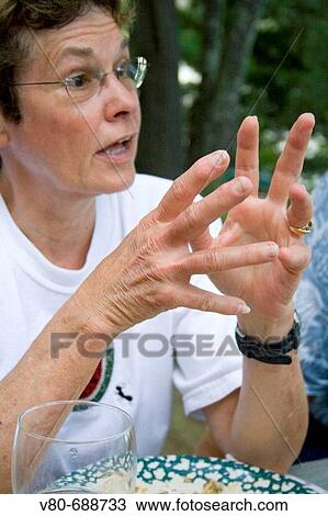 Stock Image - Woman age 63 in deep conversation at the picnic table Danbury Wisconsin USA. Fotosearch