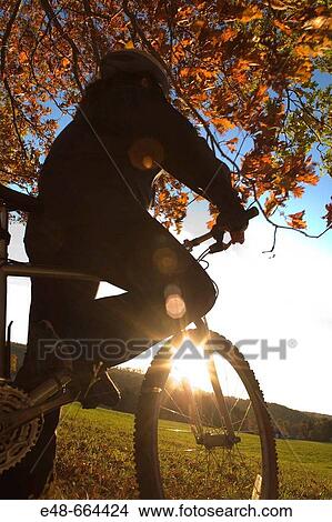 Woman alone outdoors on bicycle View Large Photo Image Picture - Woman alone outdoors on bicycle. Fotosearch