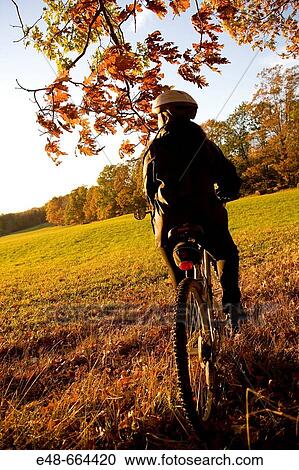 Woman alone outdoors on bicycle View Large Photo Image Stock Image - Woman alone outdoors on bicycle. Fotosearch