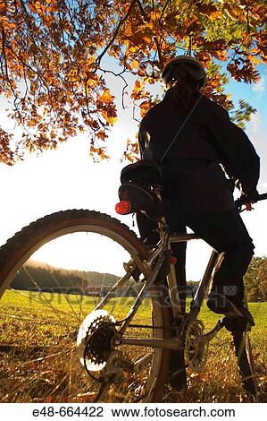 Woman alone outdoors on bicycle View Large Photo Image Stock Image - Woman alone outdoors on bicycle. Fotosearch