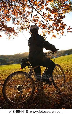 Woman alone outdoors on bicycle View Large Photo Image Stock Photo - Woman alone outdoors on bicycle. Fotosearch