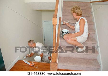 Woman and dad do touchup work on new house paint with brushes View Large Photo Image Stock Image - Woman and dad do touchup work on new house paint with brushes. Fotosearch