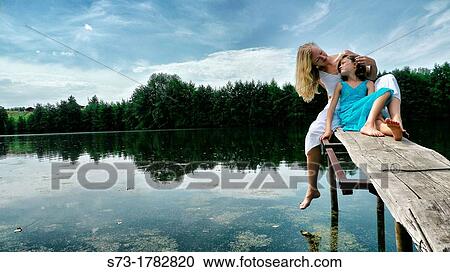 Woman and daughter on the pier in Lake Avral, Kirillovka, Samara Region, Russian Federation View Large Photo Image Stock Image - Woman and daughter on the pier in Lake Avral, Kirillovka, Samara Region, Russian Federation. Fotosearch