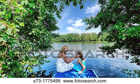 Woman and daughter on the pier in Lake Avral, Kirillovka, Samara Region, Russian Federation View Large Photo Image Stock Photography - Woman and daughter on the pier in Lake Avral, Kirillovka, Samara Region, Russian Federation. Fotosearch