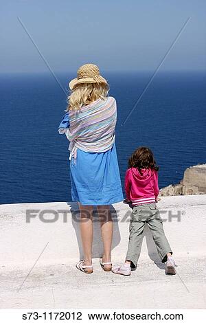 Woman and daughter watching the sea, Santorini, Oia, Cyclades Islands, Greece View Large Photo Image Stock Image - Woman and daughter watching the sea, Santorini, Oia, Cyclades Islands, Greece. Fotosearch