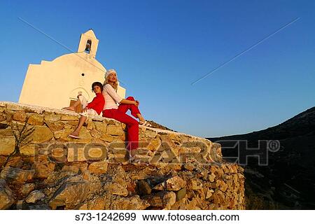 Woman and girl in an small Galissa church, Syros, Cyclades islands, Greece View Large Photo Image Stock Photo - Woman and girl in an small Galissa church, Syros, Cyclades islands, Greece. Fotosearch