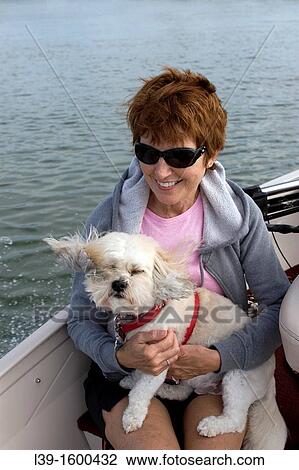 Woman and her dog riding in a boat on the Intracoastal waterway in Crescent Beach, FL, USA View Large Photo Image Stock Image - Woman and her dog riding in a boat on the Intracoastal waterway in Crescent Beach, FL, USA. Fotosearch