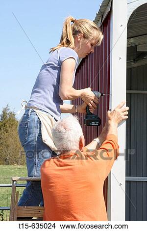 Picture - Woman and her father building a shed. Fotosearch