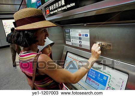 Woman and her son buying a single journey ticket from a ticket issuing machine in the subway, Hong Kong Island, Hong Kong, China. View Large Photo Image Stock Image - Woman and her son buying a single journey ticket from a ticket issuing machine in the subway, Hong Kong Island, Hong Kong, China.. Fotosearch