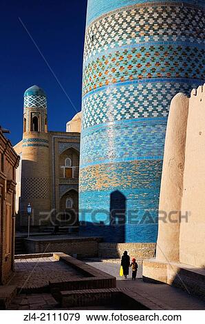 Woman and her son walking by the unfinished minaret Kalta Minor. Uzbekistan, Khorezm, Khiva, Itchan Kala (inner town). View Large Photo Image Stock Photo - Woman and her son walking by the unfinished minaret Kalta Minor. Uzbekistan, Khorezm, Khiva, Itchan Kala (inner town).. Fotosearch