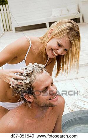 Stock Image - Woman and man washing hair. Fotosearch