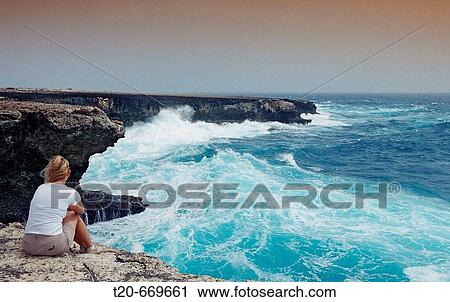 Stock Image - Woman and stormy coast, Netherlands Antilles, Bonaire, Caribbean Sea, Washington Slagbaai National Park, Suplad?. Fotosearch