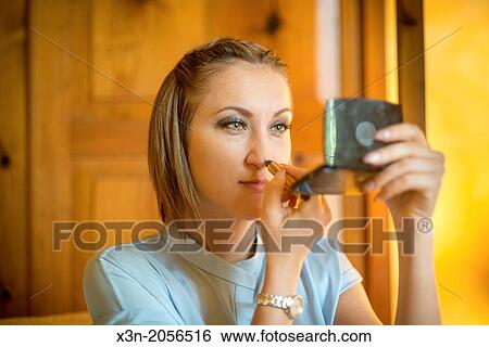 Stock Photograph - Woman applies makeup.. Fotosearch