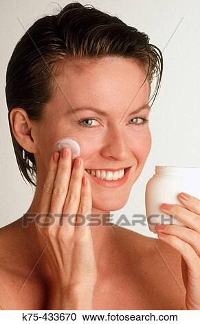 Stock Image - Woman applying beauty cream. Fotosearch