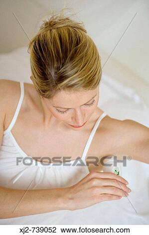 Stock Image - Woman applying deodorant. Fotosearch