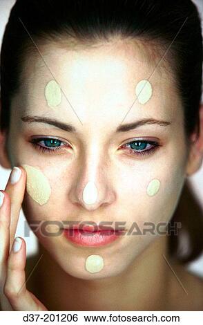 Stock Photograph - Woman applying facial cream. Fotosearch