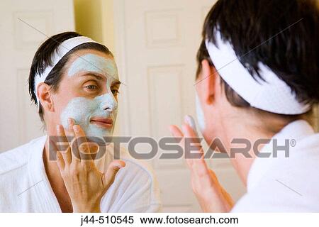 Woman applying green facial mask in the bathroom View Large Photo Image Stock Photography - Woman applying green facial mask in the bathroom. Fotosearch