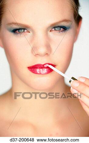 Stock Photo - Woman applying lipstick. Fotosearch