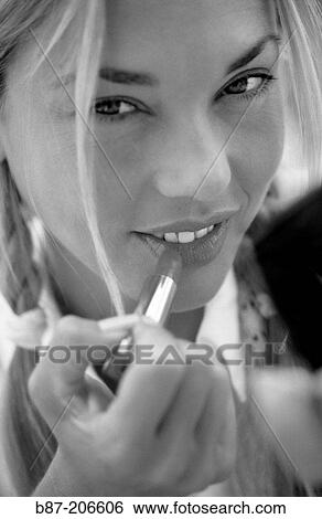 Woman applying lipstick View Large Photo Image Stock Photograph - Woman applying lipstick. Fotosearch