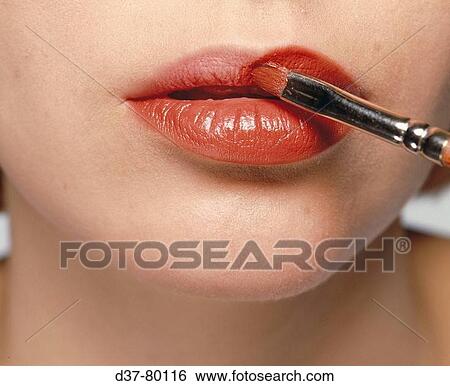 Woman applying lipstick View Large Photo Image Stock Photograph - Woman applying lipstick. Fotosearch