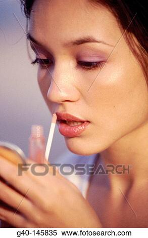 Woman applying lipstick View Large Photo Image Stock Photography - Woman applying lipstick. Fotosearch