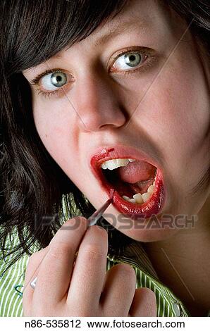 Woman applying lipstick with a brush View Large Photo Image Stock Image - Woman applying lipstick with a brush. Fotosearch