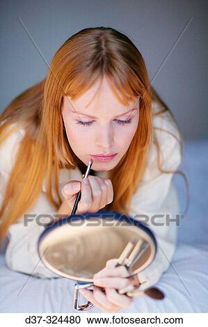 Stock Image - Woman applying make-up. Fotosearch
