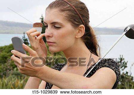 woman applying makeup while golfing View Large Photo Image Stock Photo - woman applying makeup while golfing. Fotosearch