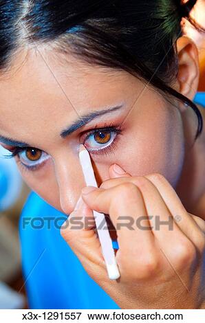 Woman applying white eye liner View Large Photo Image Stock Photo - Woman applying white eye liner. Fotosearch