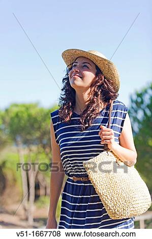 Woman arriving at the beach looking at the sky View Large Photo Image Stock Photo - Woman arriving at the beach looking at the sky. Fotosearch