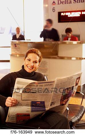Woman at airport, reading a newspaper View Large Photo Image Stock Photo - Woman at airport, reading a newspaper. Fotosearch
