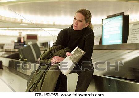 Woman at airport, waiting for the baggage View Large Photo Image Stock Photo - Woman at airport, waiting for the baggage. Fotosearch