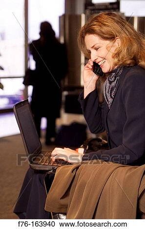 Woman at airport, with cell phone and laptop computer View Large Photo Image Stock Image - Woman at airport, with cell phone and laptop computer. Fotosearch