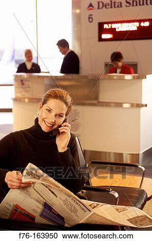 Woman at airport with cell phone View Large Photo Image Stock Image - Woman at airport with cell phone. Fotosearch