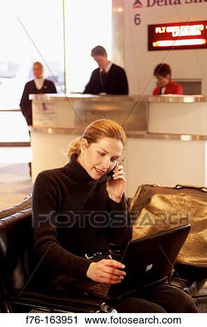 Woman at airport with cell phone View Large Photo Image Stock Image - Woman at airport with cell phone. Fotosearch