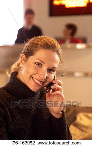 Woman at airport with cell phone View Large Photo Image Stock Image - Woman at airport with cell phone. Fotosearch