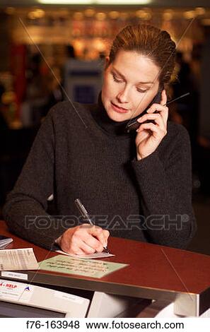 Woman at airport with cell phone View Large Photo Image Stock Photo - Woman at airport with cell phone. Fotosearch