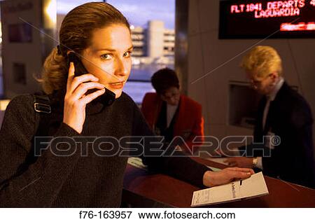 Woman at airport with cell phone View Large Photo Image Stock Photo - Woman at airport with cell phone. Fotosearch